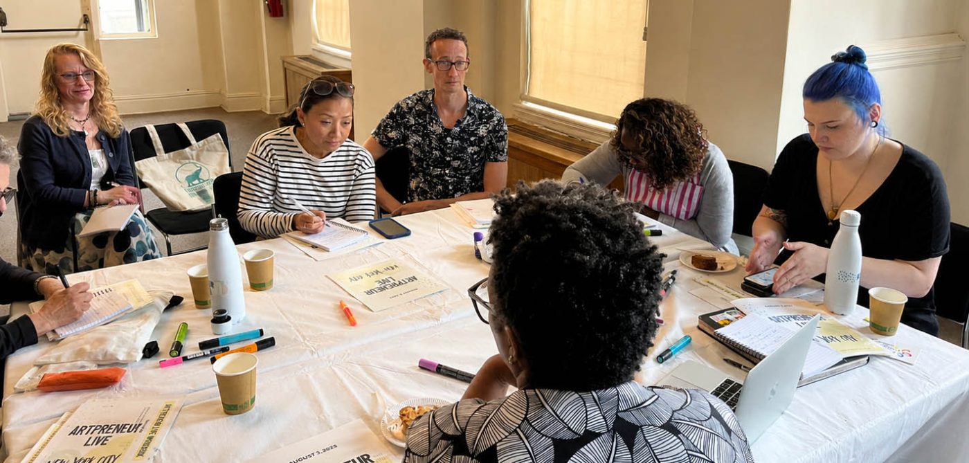 Artists collaborating around a table at an Artpreneur Live workshop in New York City